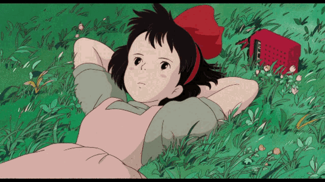 a girl with a red bow is laying in the grass with her head resting on her hands