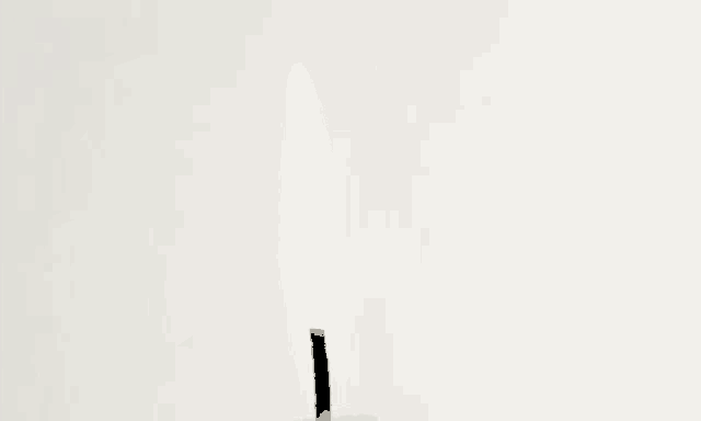 a candle with a black wick is lit up against a white background