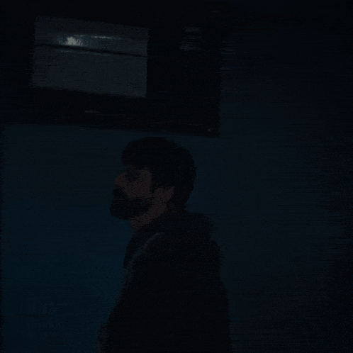 a man with a beard is in a dark room