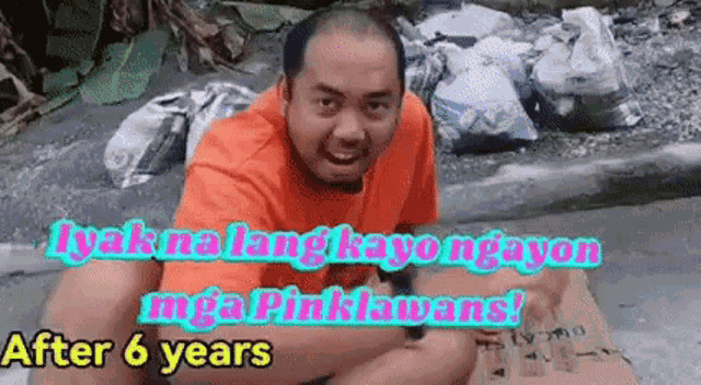 a man is sitting on the ground in front of a pile of trash and says after 6 years .