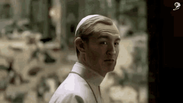 a close up of a man wearing a white hat and a white shirt .