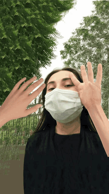 a woman wearing a face mask is being touched by a hand