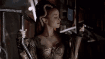a woman is standing in a dark room with a lightning bolt coming from her hand .