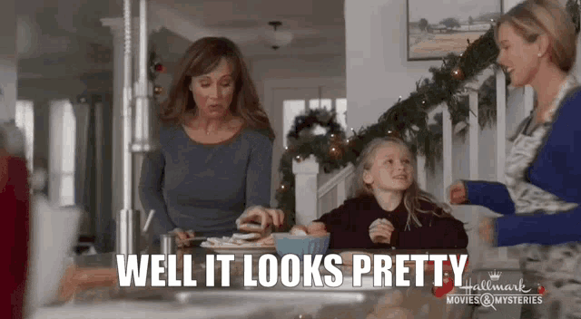 two women and a little girl are sitting at a table with a bowl of food .