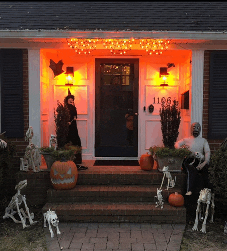 a house decorated for halloween with pumpkins and skeletons