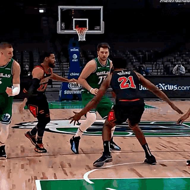 a basketball player with the number 21 on his back dribbles the ball
