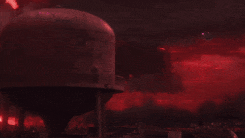 a person is standing in a dark room with a red light coming from their chest