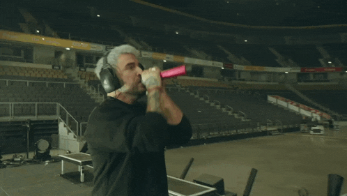 a man wearing headphones sings into a microphone