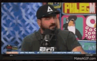 a man wearing a hat and glasses is speaking into a microphone on espn