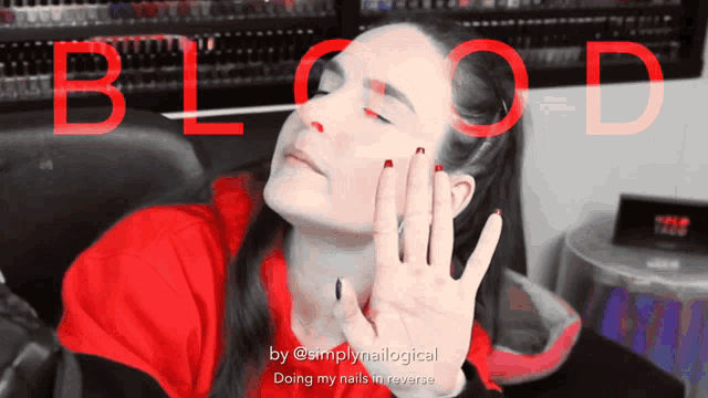 a woman in a red shirt is doing her nails in reverse with the word blood behind her