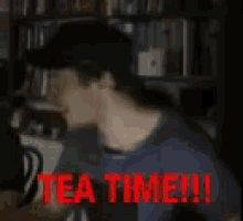 a man is drinking tea from a red cup with the words tea time in red