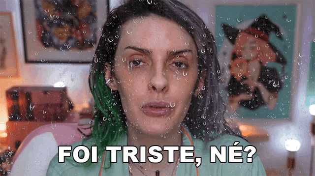 a woman with green hair says " foi triste ne " in front of a window with rain drops on it