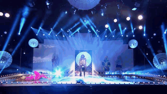 a group of people standing on a stage with blue lights behind them