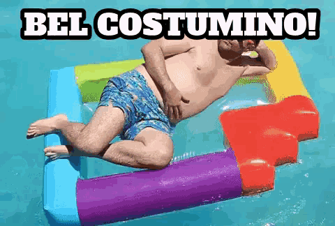 a shirtless man is laying on an inflatable in a pool with the words bel costumino written above him