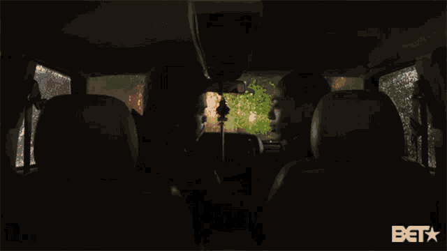 two men are sitting in the back seat of a car with a bet logo in the corner