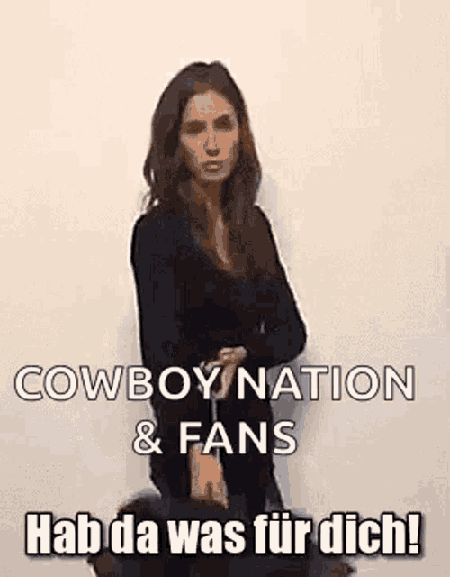 a woman is standing in front of a white wall with her arms crossed and a cowboy nation & fans hashtag .