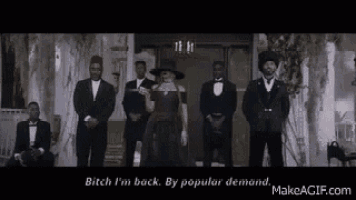 a woman is standing in front of a group of men in suits .