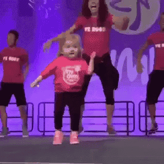 a little girl wearing a shirt that says " my butt " is dancing on stage