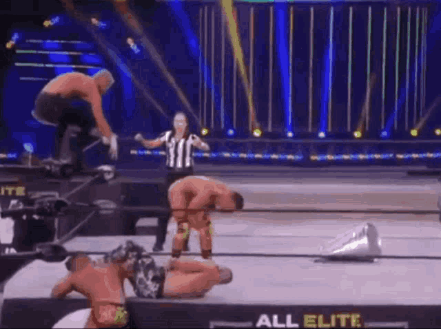 a referee is standing in the middle of a wrestling match