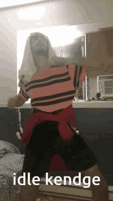 a man in a pink and black striped shirt is dancing with the words idle kendge above him