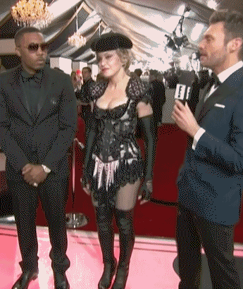 a woman in a corset is being interviewed by a man in a suit