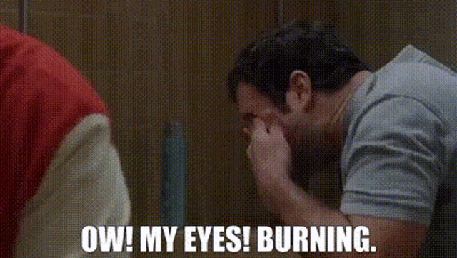 a man is covering his face with his hand while another man says `` ow ! my eyes ! burning . ''