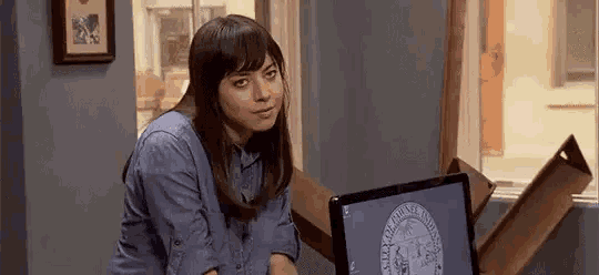 a woman is sitting in front of a computer screen in a room .