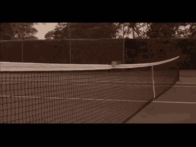 a tennis ball is hitting a tennis net on a tennis court