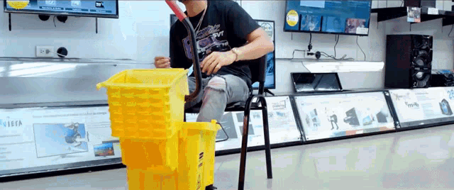a man sits in a chair next to a yellow mop bucket with the word visa on it