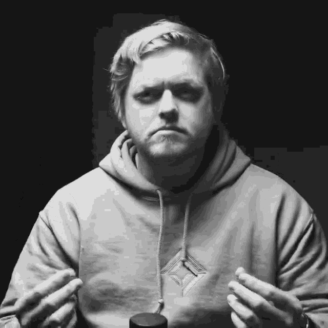 a man wearing a white hoodie with a diamond on it