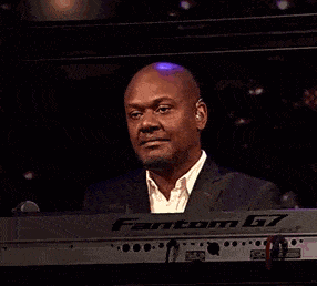 a man in a suit is smiling while playing a keyboard that says fantom
