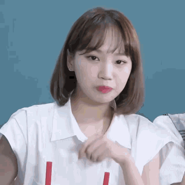 a woman with short hair is wearing a white shirt with a red l on the front .