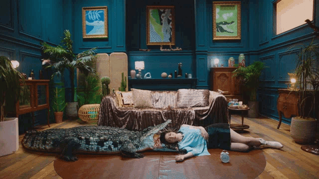 a woman laying on a bed next to a crocodile with its mouth open