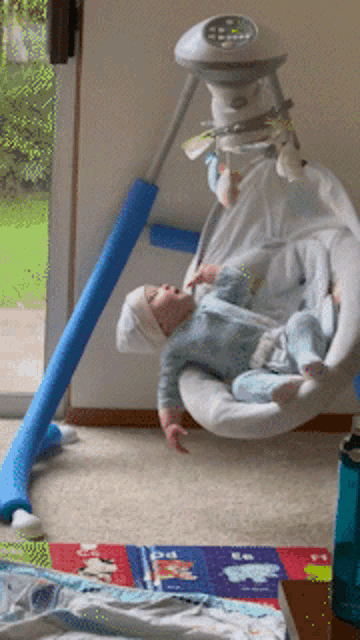a baby is laying in a swing that says ' fisher price ' on the top