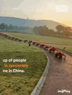 a group of people are doing push ups on a track in china .