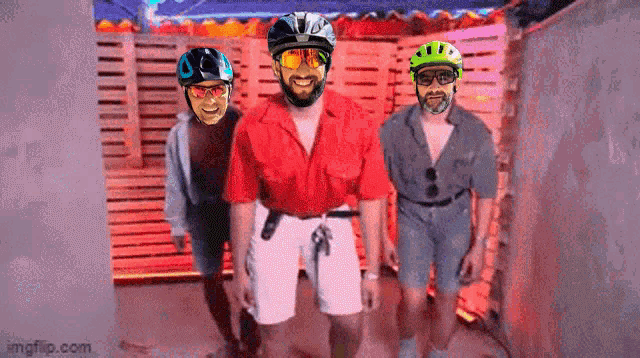 three men wearing helmets and sunglasses are standing next to each other in a room .