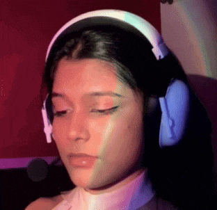 a woman wearing headphones is sitting in front of a red wall .