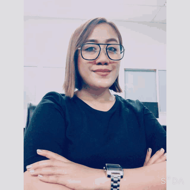 a woman wearing glasses and a watch is smiling for the camera