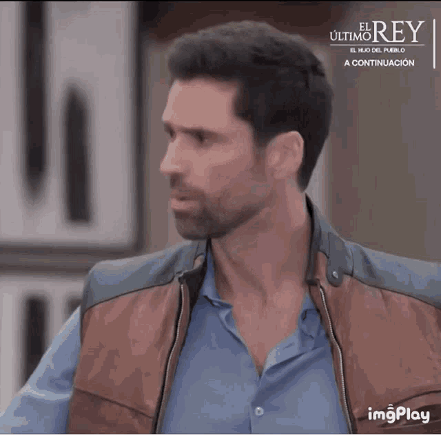 a man is wearing a brown vest and a blue shirt with the word el ultimo rey on the bottom