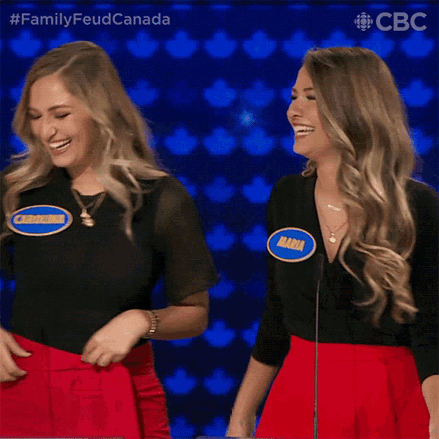 two women are laughing in front of a microphone and one of them has a name tag that says maria
