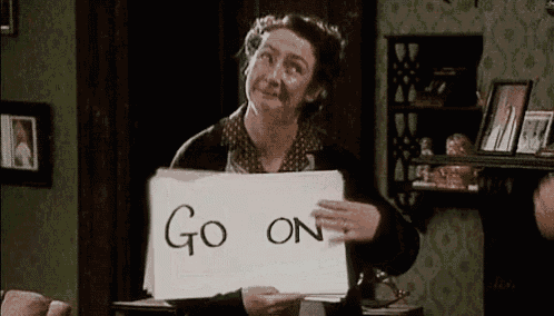 a woman is holding a piece of paper with the words `` go on '' written on it .