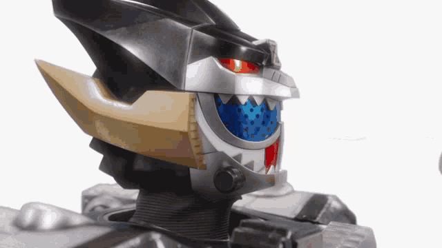 a close up of a robot 's head with a blue eye and sharp teeth