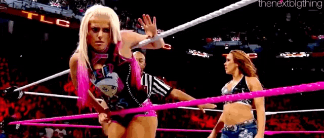 a woman in a wrestling ring is holding a pink rope .