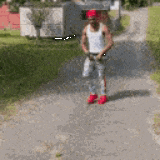 a man wearing a red hat and white tank top is walking down a dirt road .