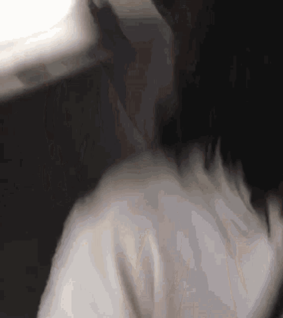 a blurry picture of a person 's neck and shoulder