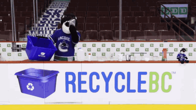 a hockey rink with a recycle bc advertisement