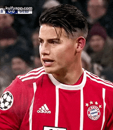 a close up of a soccer player wearing a red and white adidas jersey .