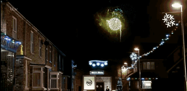 a fireworks display in front of a building that says ' rick 's kitchen ' on it