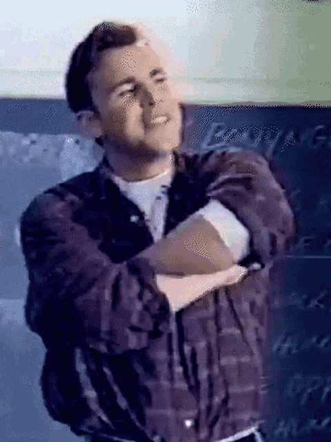 a man with his arms crossed stands in front of a blackboard that says ' engagement ' on it