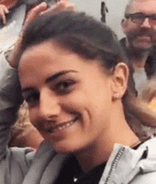 a close up of a woman 's face with her hand on her head